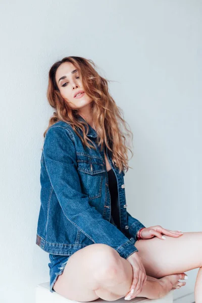 Portrait of a beautiful woman in denim shorts and lingerie — Stock Photo, Image