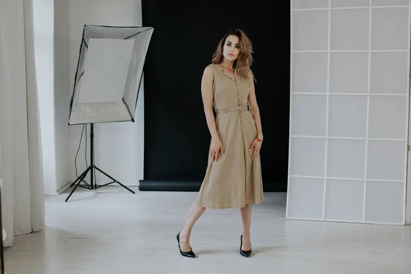 Hermosa mujer de moda en vestido beige en habitación vacía —  Fotos de Stock