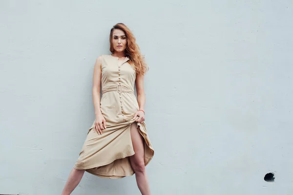 Retrato de una mujer de moda en un vestido beige sobre un fondo gris —  Fotos de Stock