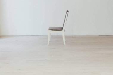 Boş beyaz bir odanın içindeki gri sandalye.