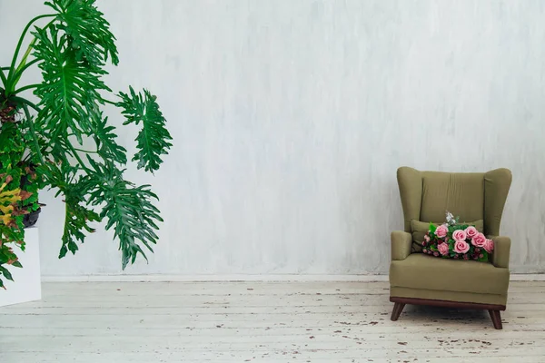 Chaise verte avec des fleurs et des plantes à l'intérieur de la chambre grise — Photo