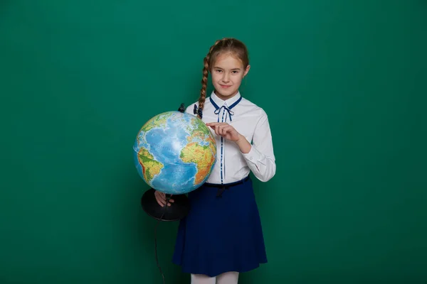 Girl with a globe in geography class at the board at school — Stock Photo, Image