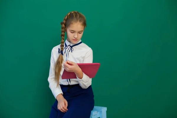 Ragazza con un tablet internet in una lezione al consiglio di amministrazione a scuola — Foto Stock