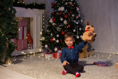 Küçük çocuk Noel arifesinde Noel ağacı hediyelerinde ışık çelenkleri