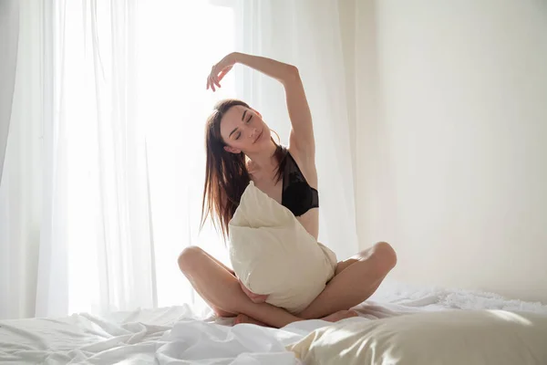 Vacker kvinna i linne i sovrummet på sängen — Stockfoto
