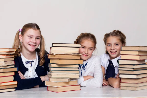 Thre girls with books in class at a desk at school — Stock Photo, Image