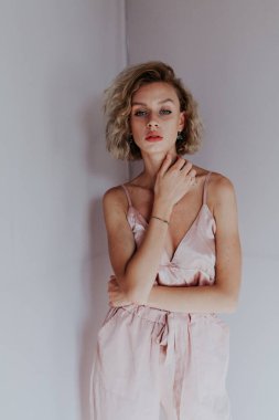 Pembe tulumlu güzel ve şık bir kadının portresi.