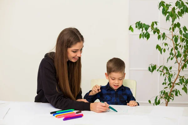 Мама и сын учатся рисовать картины дома за столом — стоковое фото