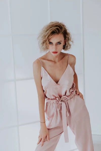 Портрет красивой модной женщины в розовом комбинезоне — стоковое фото