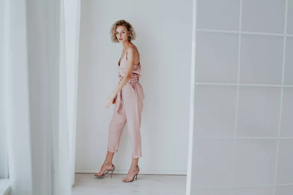 Retrato de una hermosa mujer de moda en un mono rosa —  Fotos de Stock