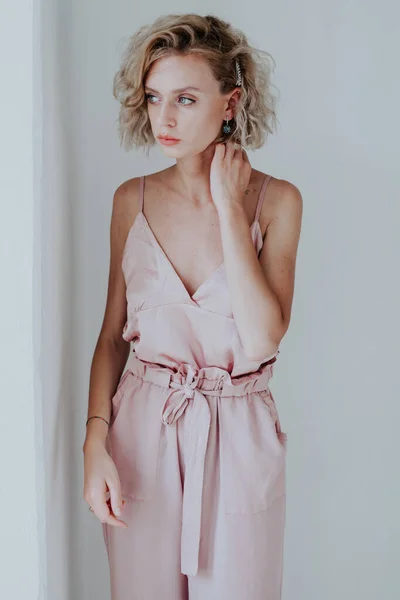 Retrato de uma bela mulher na moda em um macacão rosa — Fotografia de Stock