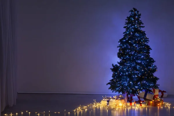 Árbol de Navidad con regalos y luces guirnaldas año nuevo fondo de vacaciones — Foto de Stock