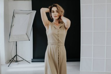 Yürüyüşe çıkmış bej elbiseli güzel bir kadının portresi.