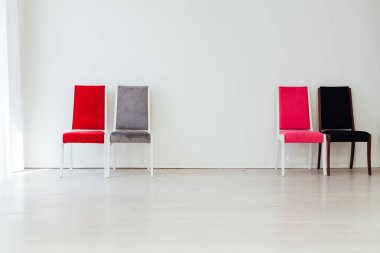 Boş beyaz bir odanın içinde dört sandalye.