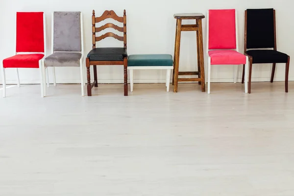 Zeven stoelen in het interieur van een lege witte kamer — Stockfoto