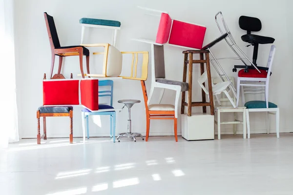 Muitas cadeiras multicoloridas no interior da sala branca — Fotografia de Stock