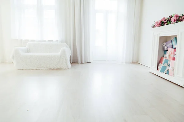 Sofá branco com lareira no interior de uma sala branca com janelas — Fotografia de Stock