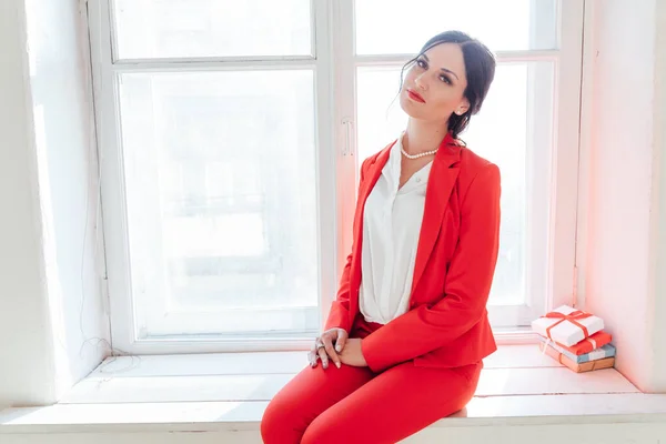 Porträt einer schönen Frau im roten Businessanzug im Büro — Stockfoto