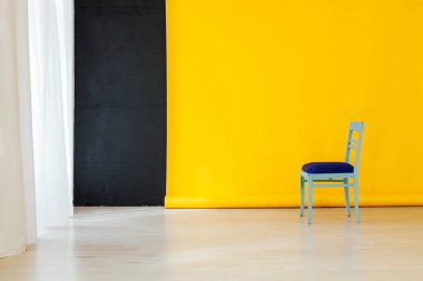 Odanın içinde sarı arka planı olan mavi sandalye.