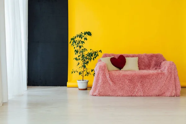 Sofá rosa no interior da sala com um fundo amarelo — Fotografia de Stock