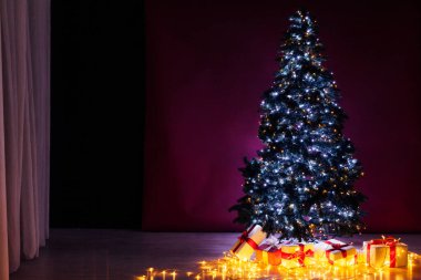 Hediyeli Noel ağacı yeni yıl için çelenkleri aydınlatır.