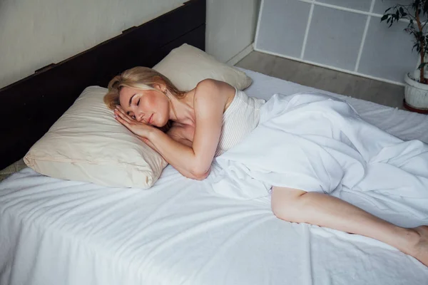 Beautiful blonde woman sleeps in the bedroom in bed — Stock Photo, Image