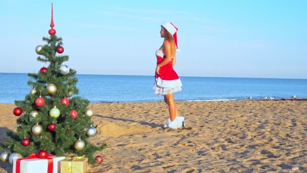 Woman on the beach with christmas tree and gifts — Stock Video