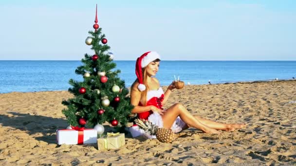 Vrouw op een tropisch strand met een kerstboom — Stockvideo