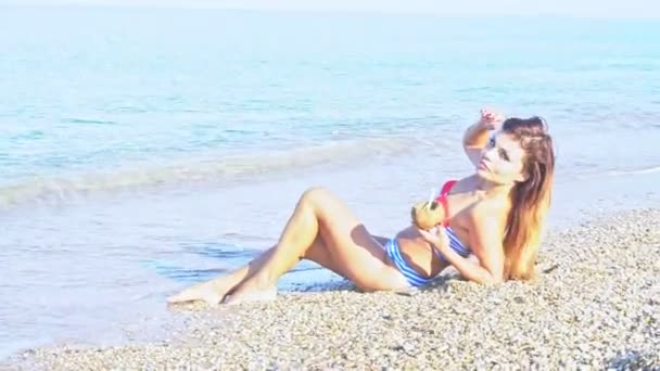 Mujer en traje de baño en la playa junto al océano — Vídeo de stock