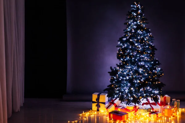 Choinka z prezentami i lampkami girlandy Nowy rok wakacje tle — Zdjęcie stockowe
