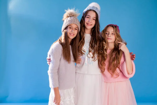 Three beautiful fashionable girls in winter cap snow — Stock Photo, Image