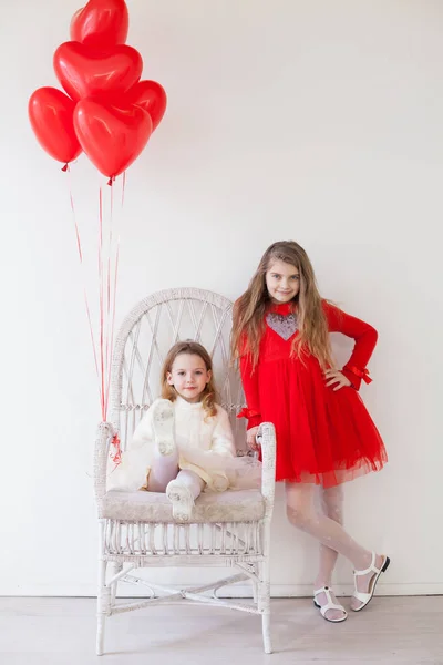 Маленька дівчинка з червоними кульками у формі серця — стокове фото