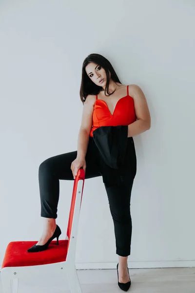 Bella donna bruna in abito da lavoro nero rosso in ufficio bianco — Foto Stock