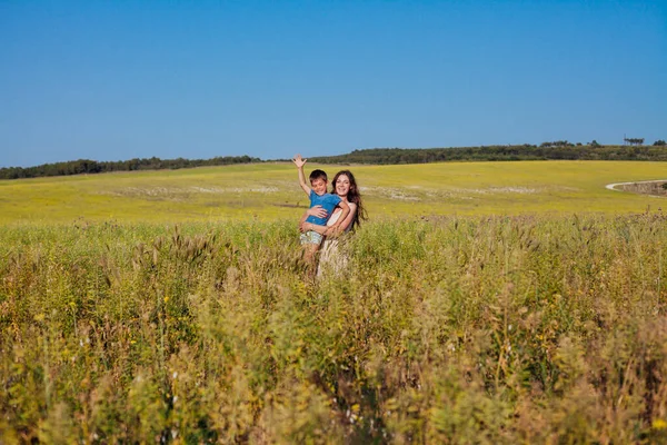 Portrait d'une belle maman et fils sur une promenade sur la route du champ de la nature — Photo