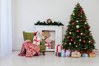 Odanın içi yılbaşı süsleri için kırmızı hediyelerle dolu bir Noel ağacı.