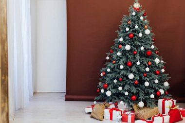 Yeni yıl için hediye dekoru olan mavi Noel ağacı beyaz bir kartpostal odasında kahverengi arka planda