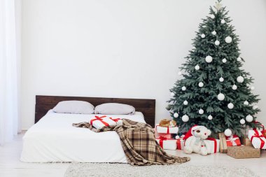 Yeni yıl için yatak odasındaki mavi Noel ağacında iç kışa özel hediyelerle çam ağaçları.