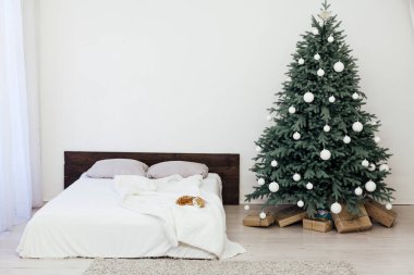 Yeni yıl için yatak odasındaki mavi Noel ağacında iç kışa özel hediyelerle çam ağaçları.