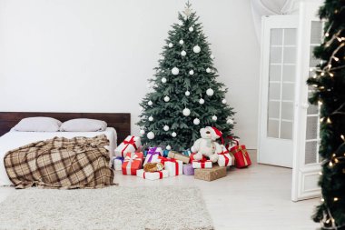 Yeni yıl için yatak odasındaki mavi Noel ağacında iç kışa özel hediyelerle çam ağaçları.