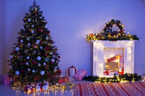 除夕之夜 室内的圣诞树松树上有礼物 壁炉点着灯 装饰着圣诞前夜的花环 — 图库照片