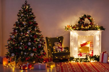 Noel ağacı çamı hediyeler, şömine ışıkları, gece yeni yıl arifesinde odanın içinde çelenkler.