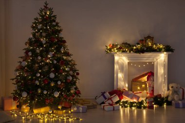Noel ağacı çamı hediyeler, şömine ışıkları, gece yeni yıl arifesinde odanın içinde çelenkler.