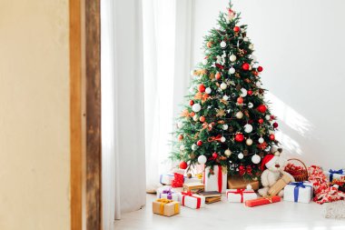 Noel ağacı çamı, beyaz odanın içinde yeni yıl için çiçek ışıklarının hediyeleriyle bir zemin olarak.