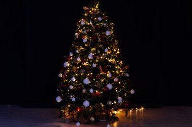 Noel ağacı çamı, gece odasının içinde yeni yıl için çiçek ışıklarının hediyeleriyle bir zemin olarak.