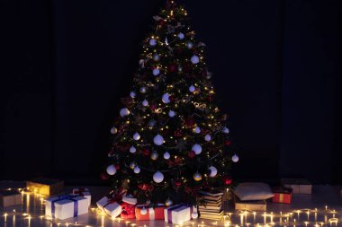 Noel ağacı çamı, gece odasının içinde yeni yıl için çiçek ışıklarının hediyeleriyle bir zemin olarak.