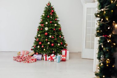 Noel ağacı hediyelerle süslenir. Yeni yıl süslenir. Evin beyaz odasının içi.