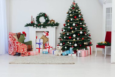 Beyaz oda içi şömineli Noel ağacı. Yeni yıl süslemeleri.