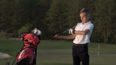 Golf sahasında onun çekim için beklerken genç golfçü fidgets