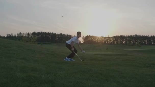Ευτυχισμένο αγόρι παίχτης του γκολφ. Χαρούμενα junior αγόρι στο γήπεδο γκολφ στο ηλιοβασίλεμα — Αρχείο Βίντεο