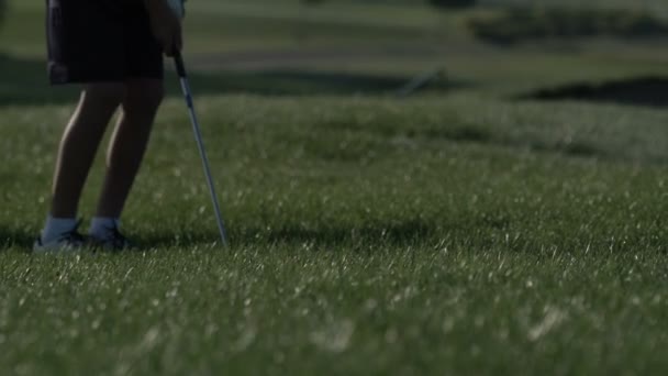 Junior golfista jugando al golf en verano con tiro de golpear en la hierba verde — Vídeos de Stock